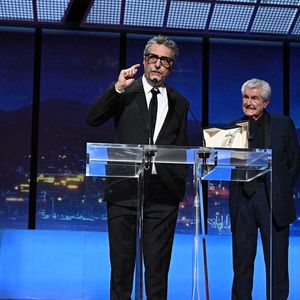 Le réalisateur brésilien Kleber Mendonca Filho reçoit le prix du meilleur réalisateur et est accompagné par le réalisateur français Claude Lelouch pour le film "O Agente Secreto" (L'agent secret) du réalisateur français Claude Lelouch lors de la cérémonie de clôture de la 78e édition du Festival de Cannes à Cannes, dans le sud de la France, le 24 mai 2025.