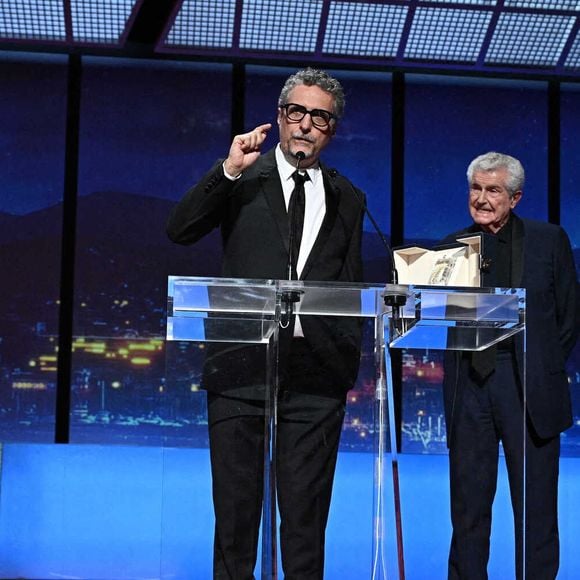 Le réalisateur brésilien Kleber Mendonca Filho reçoit le prix du meilleur réalisateur et est accompagné par le réalisateur français Claude Lelouch pour le film "O Agente Secreto" (L'agent secret) du réalisateur français Claude Lelouch lors de la cérémonie de clôture de la 78e édition du Festival de Cannes à Cannes, dans le sud de la France, le 24 mai 2025.