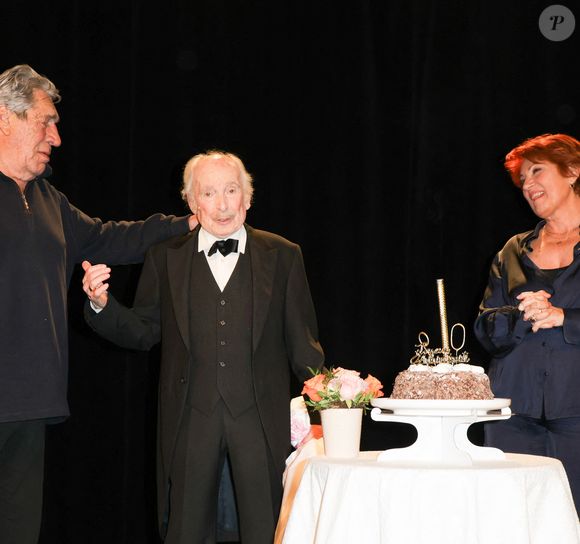 Le doyen de l'humour français a également eu droit à une petite surprise de la part de ses proches. Certains visages phares du 7ème art français et du petit écran n'auraient pour rien au monde loupé cette représentation particulièrement symbolique !

Popeck, Jean-Pierre Castaldi et Véronique Genest - Anniversaire surprise de Popeck à l'occasion de ses 90 ans sur la scène du théâtre de Passy à Paris le 18 mai 2025. © Coadic Guirec/Bestimage