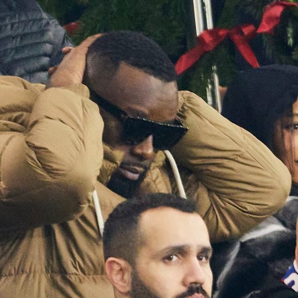 Gims et sa femme DemDem dans les tribunes du match de Ligue 1 McDonald's opposant le Paris Saint-Germain (PSG) à Lyon (3-1) au Parc des Princes à Paris le 15 décembre 2024. © Cyril Moreau/Bestimage