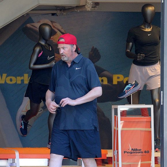 Exclusif - Matthew Perry va s'acheter des vêtements de sport Nike au centre commercial The Grove à Los Angeles, le 28 août 2023. Accompagné de son assistant, la star de "Friends" est ressorti de la boutique vêtu d "un nouveau tee-shirt et d'un short flambant neuf. Auteur d'une autobiographie à succès, l'acteur de 54 ans semble toujours fumer beaucoup à en croire la coloration orangée de son index.