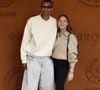 Décontracté avec ses lunettes de soleil, un pull blanc, un long short en jean bleu et des mocassins laissant apparaître ses grandes chaussettes, Stromae a pris la pose avec son épouse...

Stromae et sa femme Coralie Barbier lors des Internationaux de France de Tennis de Roland Garros 2026, à Paris, France, le 7 juin 2026. © Jacovides-Moreau/Bestimage