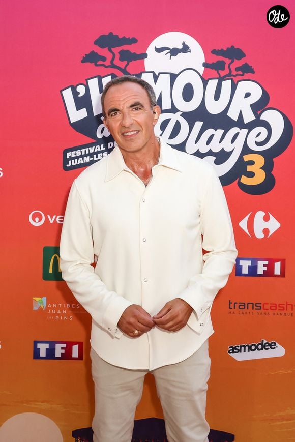 Exclusif - Nikos Aliagas lors de la 3ème édition du festival L’Humour à la Plage à Juan les Pins, France, le 27 juin 2026. C'est l'humoriste français K.Adams qui a initié et mis en scène ce festival dans la ville de ses grand-parents où il a passé ses vacances quand il était plus jeune. Après le succès des éditions précédentes, TF1 et K.Adams donnent rendez-vous au public pour des soirée d’humour inédite et festive. Cette année, deux soirées spectacle ont été programmées avant l'enregistrement des deux shows télévisiés. C'est N.Arial, avec son one man "Pas Comme Eux" qui va ouvrir le Festival suivi, le lendemain par F.Eboué et son spectacle "Solitudes". Tourné face à la mer, dans l’écrin magique de la pinède Gould à Juan-les-Pins, « L’Humour à la Plage » revient pour une 3ème édition encore plus ambitieuse : un grand show à ciel ouvert, pour rire ensemble et démarrer l’été en beauté. Une carte postale en guise de scène avec une ambiance unique. Imaginé comme une véritable fête de l’humour à ciel ouvert, sous les pins, les pieds dans le sable et la tête dans les étoiles, « L’Humour à la Plage » rassemble le temps d’un soir les plus grands noms de l’humour avec des duos inédits, des sketchs exclusifs, des impros, des happenings, des surprises… et une énergie communicative portée par un public survolté. Une programmation exceptionnelle qui donne le sourire. Diffusée le 27 août sur TF1. © Bebert-Tribeca/Bestimage