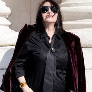 Fidèle à son aura rock et rebelle, la comédienne a opté pour un look garçonne implacable : chemise noire, cravate lâche, veste en velours jetée sur les épaules et l'éternelle cigarette à la main.

Béatrice Dalle aux arrivées du deuxième défilé de mode Saint Laurent Prêt à Porter Collection Homme Printemps/Été 2027 lors de la Fashion Week de Paris à la Bourse de Commerce - Pinault Collection, à Paris, France, le 23 juion 2026. © Olivier Borde/Bestimage