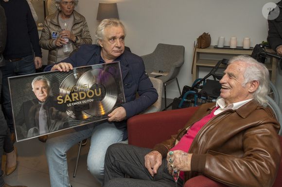 Exclusif - Michel Sardou pose avec son double disque de platine devant Jean-Paul Belmondo - People au concert ultime de Michel Sardou pour la dernière date de son spectacle "La dernière danse" à la Seine Musicale à Boulogne-Billancourt le 11 avril 2018. Le chanteur a rassemblé plus de 400 000 spectateurs pour une tournée de 82 concerts. © Pierre Perusseau/Bestimage
