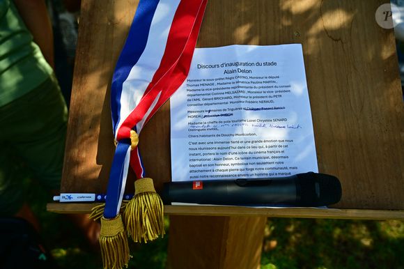 Une cérémonie en hommage à Alain Delon a été organisée un an jour pour jour après la mort de l'acteur, à Douchy-Montcorbon (Loiret), France, le 18 août 2025, commune où la star a vécu durant plusieurs décennies, une plaque a été dévoilée à l'intérieur du stade en honneur de l'acteur, qui avait équipé en 1983 les équipes de football de jeunes de Douchy de maillots à son nom et une projection d'un film documentaire de 45 mn "Delon-Douchy", écrit autour de la relation entre l'acteur et la commune, est aussi programmée en début de soirée dans la salle des fêtes communale. © Christian Liewig/Bestimage