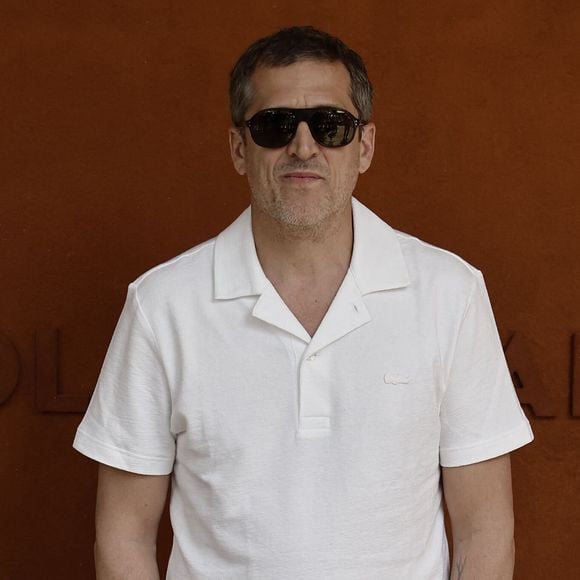 Le réalisateur et comédien a misé sur un polo blanc à col ouvert, porté avec un pantalon noir ample et une paire de baskets sombres.

Guillaume Canet lors des Internationaux de France de Tennis de Roland Garros 2026, à Paris, France, le 7 juin 2026. © Jacovides-Moreau/Bestimage