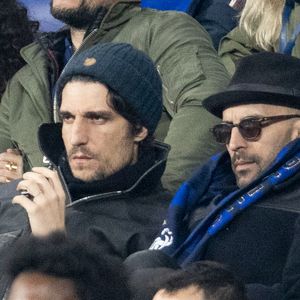 Louis Garrel et l'artiste JR - Célébrités dans les tribunes du quart de finale de la Ligue des Nations de l'UEFA 2025 "France - Croatie (2-0 / tab 5-4)" au Stade de France à Saint-Denis le 23 mars 2025. © Cyril Moreau/Bestimage