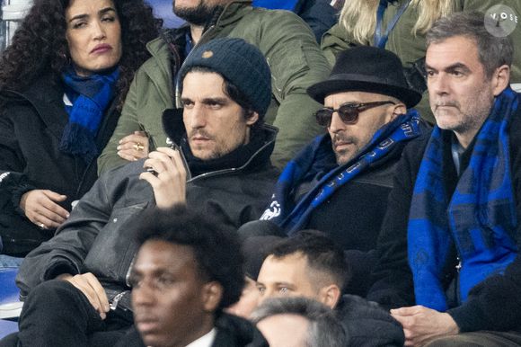Louis Garrel et l'artiste JR - Célébrités dans les tribunes du quart de finale de la Ligue des Nations de l'UEFA 2025 "France - Croatie (2-0 / tab 5-4)" au Stade de France à Saint-Denis le 23 mars 2025. © Cyril Moreau/Bestimage
