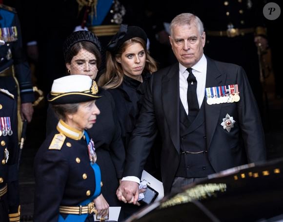 Leur père, le prince Andrew entaché par un nouveau scandale, brillera lui aussi par son absence... 

La princesse Anne, la princesse Eugenie d'York, la princesse Beatrice d'York et le prince Andrew - Procession cérémonielle du cercueil de la reine Elisabeth II du palais de Buckingham à Westminster Hall à Londres le 14 septembre 2022.