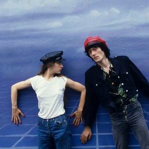 Archive - En France, durant leur tournée, Catherine Ringer et Fred Chichin, portant une casquette, debout devant un fond bleu ciel. © Michel Croizard via Bestimage