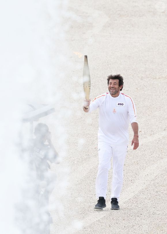 Le chanteur et acteur Patrick Bruel porteur de la flamme olympique des Jeux Olympiques de Paris 2024 (JO) au château de Versailles dans les Yvelines, France, le 23 juillet 2024. © Dominique Jacovides/Bestimage