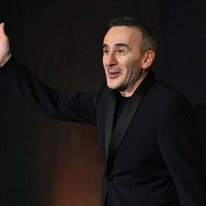EXCLUSIF - Elie Semoun, humoriste, acteur, scénariste et réalisateur français, s'est produit bénévolement avec son nouveau spectacle, « Cactus », lors d'une soirée unique dans les salons du Musée Masséna à Nice, le 22 janvier 2026, au profit de la Fondation Claude Pompidou, et organisée par le célèbre artiste plasticien Stéphane Bolongaro, connu pour ses statues représentant le chien Totor. L’événement s’est déroulé en présence de l’animatrice, mannequin et marraine de la soirée, Adriana Karembeu, du documentariste et journaliste Olivier Delacroix, du maire de Nice Christian Estrosi et de son épouse Laura Tenoudji.
Dans ce nouveau spectacle, c'est Elie Semoun qui assure lui-même la première partie avec l'un de ses personnages fétiches, s'essayant pour l'occasion au stand-up, puis revient sur son amitié avec son complice de ses débuts, Dieudonné, mais raconte aussi l'histoire d'un homosexuel qui veut s’engager dans le djihadisme, ou d'un personnage handicapé moteur qui s’engueule avec sa copine, en fauteuil roulant, ou de ce mari perdu dans les allées d’un supermarché qui appelle sa femme à l’aide au téléphone alors qu’elle est hospitalisée pour une chimiothérapie. Une soirée placée sous le signe de l'humour caustique et des envolées lyriques. Personne n'a été épargné, pas même le maire de Nice, ni son ami Olivier Delacroix surpris en train d'envoyer des SMS en plein spectacle. Un spectacle de plus d'une heure et demie dans ce lieu insolite qu'est le Musée, qui a accueilli l'espace d'une soirée 150 personnes dans des conditions haut de gamme, comme l'a souhaité Stéphane Bolongaro, qui s'investit et donne aussi beaucoup pour la Fondation Claude Pompidou tout au long de l'année. Le public et les artistes ont pu se retrouver autour d’un cocktail dînatoire organisé par le chef étoilé Alain Llorca, de Saint-Paul-de-Vence, une commune proche de Nice, et tout cela pour 45 €, le prix du billet. Adriana, accessible et disponible, s'est prêtée au jeu des selfies pour le plus grand plaisir du public, et surtout du conservateur et directeur du musée Masséna, Jean-Pierre Barbero, qui a pu prendre sa photo officielle avec le top model près d'une sculpture de Stéphane Bolongaro installée à l'entrée. © Bruno Bebert/Bestimage