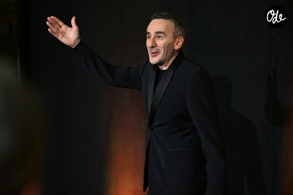 EXCLUSIF - Elie Semoun, humoriste, acteur, scénariste et réalisateur français, s'est produit bénévolement avec son nouveau spectacle, « Cactus », lors d'une soirée unique dans les salons du Musée Masséna à Nice, le 22 janvier 2026, au profit de la Fondation Claude Pompidou, et organisée par le célèbre artiste plasticien Stéphane Bolongaro, connu pour ses statues représentant le chien Totor. L’événement s’est déroulé en présence de l’animatrice, mannequin et marraine de la soirée, Adriana Karembeu, du documentariste et journaliste Olivier Delacroix, du maire de Nice Christian Estrosi et de son épouse Laura Tenoudji.
Dans ce nouveau spectacle, c'est Elie Semoun qui assure lui-même la première partie avec l'un de ses personnages fétiches, s'essayant pour l'occasion au stand-up, puis revient sur son amitié avec son complice de ses débuts, Dieudonné, mais raconte aussi l'histoire d'un homosexuel qui veut s’engager dans le djihadisme, ou d'un personnage handicapé moteur qui s’engueule avec sa copine, en fauteuil roulant, ou de ce mari perdu dans les allées d’un supermarché qui appelle sa femme à l’aide au téléphone alors qu’elle est hospitalisée pour une chimiothérapie. Une soirée placée sous le signe de l'humour caustique et des envolées lyriques. Personne n'a été épargné, pas même le maire de Nice, ni son ami Olivier Delacroix surpris en train d'envoyer des SMS en plein spectacle. Un spectacle de plus d'une heure et demie dans ce lieu insolite qu'est le Musée, qui a accueilli l'espace d'une soirée 150 personnes dans des conditions haut de gamme, comme l'a souhaité Stéphane Bolongaro, qui s'investit et donne aussi beaucoup pour la Fondation Claude Pompidou tout au long de l'année. Le public et les artistes ont pu se retrouver autour d’un cocktail dînatoire organisé par le chef étoilé Alain Llorca, de Saint-Paul-de-Vence, une commune proche de Nice, et tout cela pour 45 €, le prix du billet. Adriana, accessible et disponible, s'est prêtée au jeu des selfies pour le plus grand plaisir du public, et surtout du conservateur et directeur du musée Masséna, Jean-Pierre Barbero, qui a pu prendre sa photo officielle avec le top model près d'une sculpture de Stéphane Bolongaro installée à l'entrée. © Bruno Bebert/Bestimage