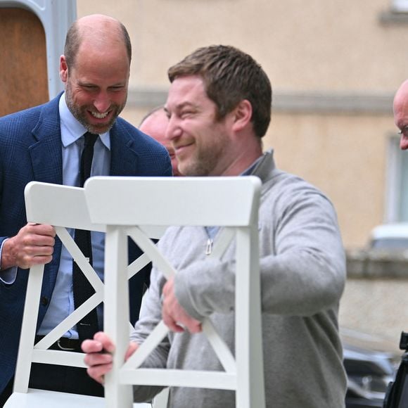 Le prince est engagé depuis plusieurs années dans cette cause.

Le prince William aide un locataire à transporter des meubles dans son nouvel appartement lors d'une visite à l'association de logement social Langstane, à Aberdeen le 30 juin 2026.
Andy Buchanan/WPA-Pool/Julien Burton/ Bestimage
