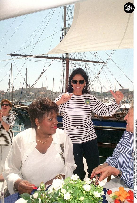 « Mouna Ayoub pose aux côtés de la chanteuse Gloria Gaynor lors de l’exposition qui lui est consacrée au Musée de la Mode de Marseille. Elle porte une robe de haute couture et est photographiée en plan américain, avec en arrière-plan le voilier de luxe Phocéa amarré dans le port. Photo : Bertrand Rindoff Petroff / Bestimage. »