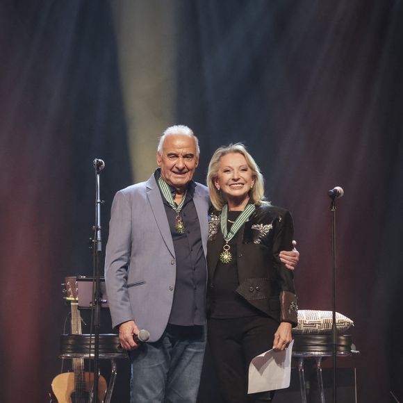 Exclusif - Michel Fugain, Véronique Sanson - Michel Fugain et Véronique Sanson se décorent mutuellement de l'Ordre des Arts et des Lettre à l'occasion du concert de Michel Fugain et de sa femme Sanda à Bobino, Paris le 27 janvier 2025.
Michel Fugain, icône de la chanson française, a célébré en 2024 ses 60 ans de carrière avec un nouvel album intitulé La Vie, l'Amour, etc....
Pour marquer cet événement, il a entamé une tournée exceptionnelle qui passera par plusieurs scènes parisiennes en 2025.
À Paris, il se produira à Bobino les lundis 13, 20 et 27 janvier, ainsi que le 3 février 2025, à 20h30. Ce spectacle, également nommé La Vie, l'Amour, etc..., propose un voyage musical à travers ses plus grands succès. Chaque chanson, portée par une interprétation pleine de générosité, promet de raviver des souvenirs et d’émouvoir le public. © Jack Tribeca / Bestimage