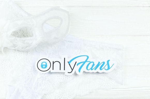 Logo OnlyFans en papier et lingerie blanche avec masque de carnaval sur une table blanche. OnlyFans est un service d'abonnement au contenu Photo by Alamy/ABACAPRESS.COM
