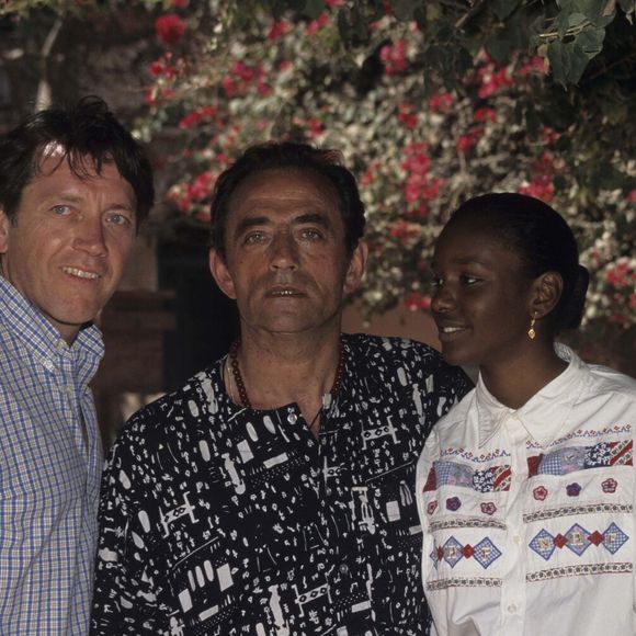 Richard Bohringer. Au Sénégal, à Gorée, l'équipe de l'émission LA GRANDE VIE et du film LES CAPRICES DU FLEUVE, à l'ombre d'un laurier, Bernard GIRAUDEAU, Richard BOHRINGER et Aissatou SOW