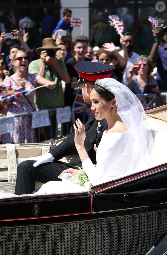 Le prince Harry, duc de Sussex, et Meghan Markle, duchesse de Sussex, en calèche à la sortie du château de Windsor après leur mariage le 19 mai 2018 (Backgrid UK/ Bestimage).