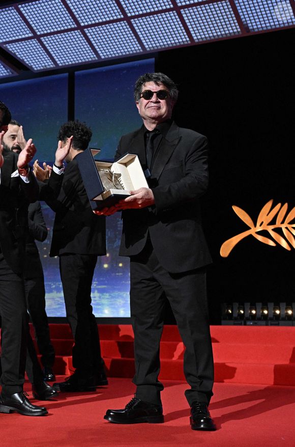 Le réalisateur, scénariste et producteur iranien Jafar Panahi célèbre sur scène après avoir remporté la Palme d'Or pour le film "Un simple accident" lors de la cérémonie de clôture de la 78e édition du Festival de Cannes à Cannes, France, le 24 mai 2025. Photo de David Niviere/ABACAPRESS.COM