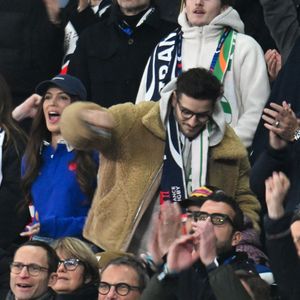 Iris Mittenaere, Jean Dujardin, Oli - Célébrités dans les tribunes du match d'ouverture du Tournoi des six nations : France-Irlande (36-14) au Stade de France à Saint-Denis le 5 février 2026. © Lionel Urman/Bestimage