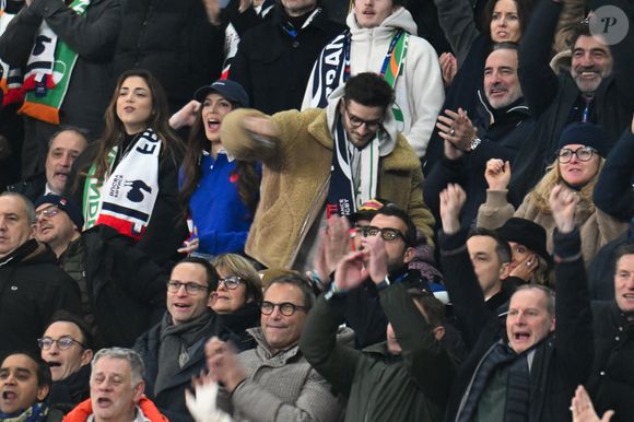 Iris Mittenaere, Jean Dujardin, Oli - Célébrités dans les tribunes du match d'ouverture du Tournoi des six nations : France-Irlande (36-14) au Stade de France à Saint-Denis le 5 février 2026. © Lionel Urman/Bestimage