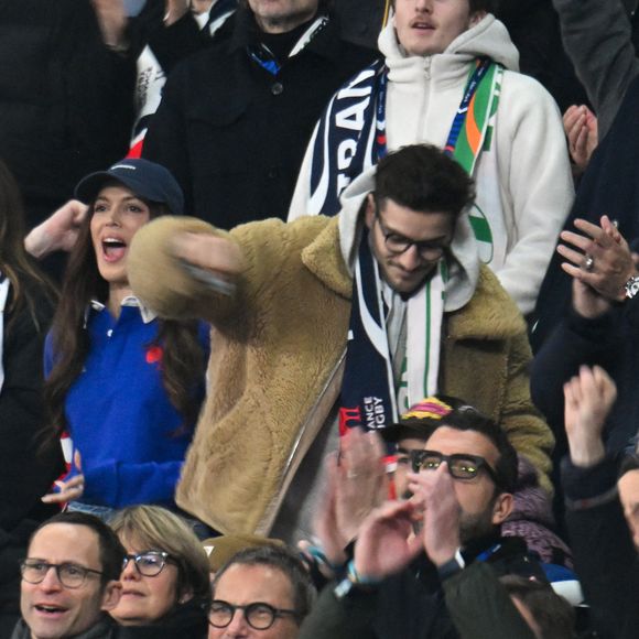 Iris Mittenaere, Jean Dujardin, Oli - Célébrités dans les tribunes du match d'ouverture du Tournoi des six nations : France-Irlande (36-14) au Stade de France à Saint-Denis le 5 février 2026. © Lionel Urman/Bestimage