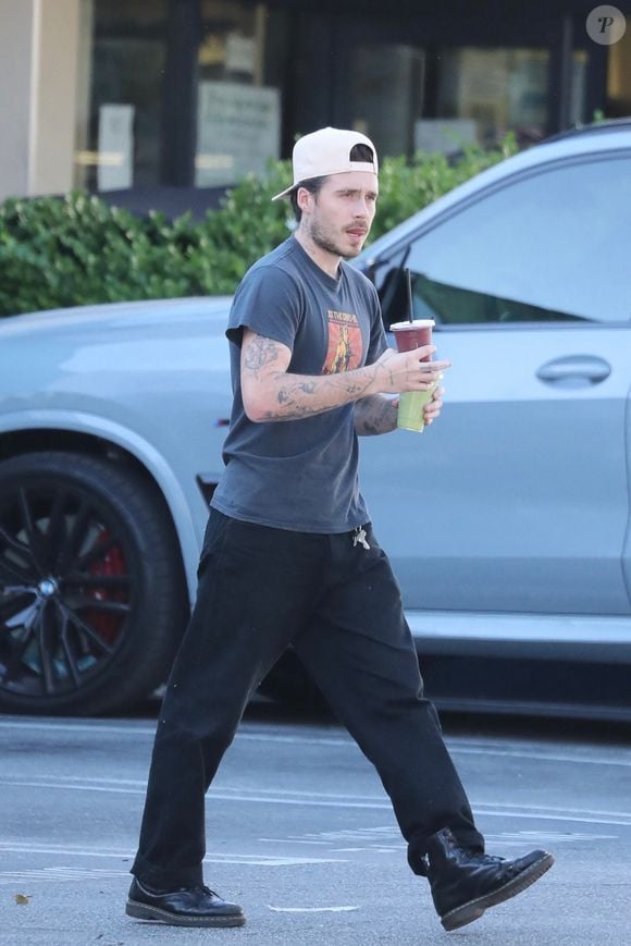 Brooklyn Beckham sort du Earth Bar à Los Angeles, portant deux boissons lors d'une sortie matinale décontractée. @ Backgrid USA / Bestimage