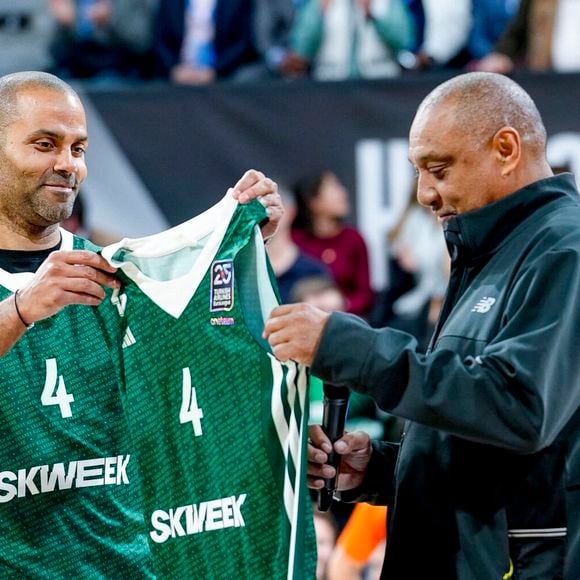 Après avoir conquis les parquets américains, l'ancienne star de la NBA change de costume et passe coach de la jeune génération.

Tony Parker remet le maillot vert historique de l'ASVEL à Delaney Rudd, ancien joueur de basket de l’ASVEL champion 1997, le 27 mars 2025. 

© Sandrine Thesillat / PsNewz / Bestimage