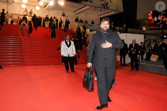 Le détail qui casse les codes habituels ? Artus a choisi de fouler le red carpet avec un imposant sac cabas en cuir noir porté à la main.

Artus - Montée des marches du film " Sanguine " lors du 79ème Festival International du Film de Cannes, le 14 mai 2026. © Jacovides-Moreau / Bestimage