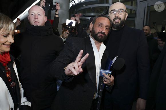 Exclusif - Cyril Hanouna se fait remettre son bagde de collaborateur du Groupe M6 par un des responsables de la sécurité - Les chroniqueurs et les invités quittent la dernière émission "Touche pas à mon poste" (TPMP) en bus pour se rendre devant le siège du groupe M6 à Neuilly-sur-Seine le 27 février 2025. © Jack Tribeca/Bestimage