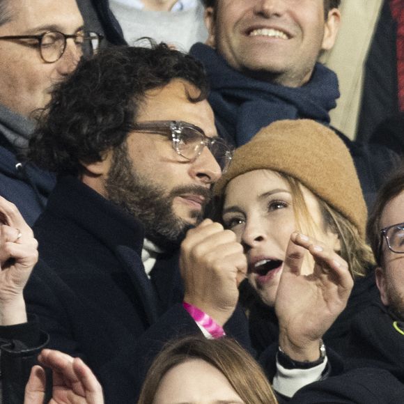 Maxim Nucci (Yodelice) et sa compagne Isabelle Ithurburu dans les tribunes lors du match de rugby du Tournoi des 6 Nations opposant la France à l'Angleterre au stade de France, à Saint-Denis, Seine Saint-Denis, France, le 19 mars 2022. La France s'offre le grand chelem dans le Tournoi des six nations, après sa victoire 25-13 contre l'Angleterre. © Cyril Moreau/Bestimage