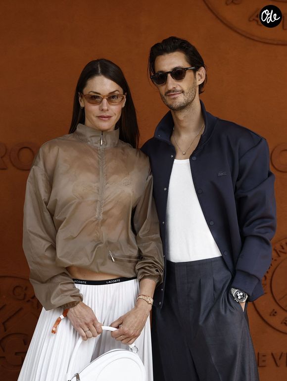 Pierre Niney portait alors un pantalon fluide et une veste bleu marine pour un look structuré mais décontracté...

Pierre Niney et sa compagne Natasha Andrews lors des Internationaux de France de Tennis de Roland Garros 2026, à Paris, France, le 7 juin 2026. © Jacovides-Moreau/Bestimage