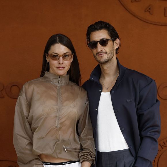 Pierre Niney portait alors un pantalon fluide et une veste bleu marine pour un look structuré mais décontracté...

Pierre Niney et sa compagne Natasha Andrews lors des Internationaux de France de Tennis de Roland Garros 2026, à Paris, France, le 7 juin 2026. © Jacovides-Moreau/Bestimage