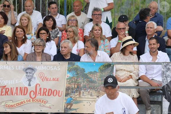Semi-exclusif - Michel Sardou et sa femme Anne-Marie Périer, Romain Sardou et sa compagne Kym Thiriot enceinte - Michel Sardou rend hommage à son père en famille lors du premier trophée de pétanque "Fernand Sardou" à Bormes-les-Mimosas le 29 mai 2026. Le célèbre chanteur est venu en famille avec sa femme, son fils Romain avec son fils de deux ans et demi et de sa compagne enceinte de son deuxième enfant.
La première édition du Trophée Fernand Sardou est organisée du 29 au 31 mai au coeur du village de Bormes les Mimosas. Une initiative portée par Michel et son fils Romain, pour rendre hommage à leur illustre parent Fernand Sardou au travers d'un tournoi de pétanque.
En lien avec la municipalité et l'Amicale Bouliste Borméenne (ABB), un premier Trophée Fernand Sardou sera organisé avec deux grands temps forts : Le vendredi, dès 18h, un tournoi d'exhibition sera proposé et verra s'affronter 16 triplettes. Puis un concours fédéral à pétanque sera organisé le weekend et ouvert à tous les amateurs. 128 équipes seront réparties sur les sites les plus emblématiques du village, à savoir au boulodrome de la place Saint-François, mais aussi au parc Cigalou, sur le site du château et à l'ancien stade. © Franz Chavaroche/Bestimage
