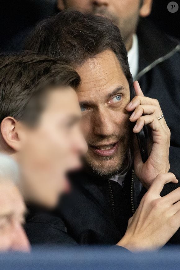 Grand Corps Malade et son fils - Célébrités dans les tribunes du match de Ligue des Champions entre le PSG contre le Bayern de Munich (1-2) au Parc des Princes à Paris le 4 novembre 2025. © Cyril Moreau/Bestimage