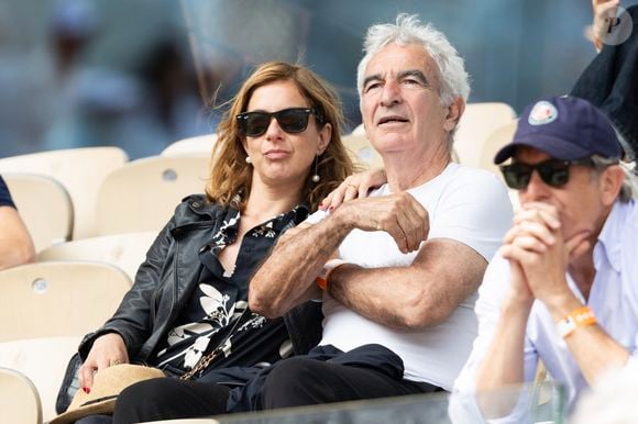 Raymond Domenech et sa compagne dans les tribunes lors des Internationaux de France de Tennis de Roland Garros 2025, à Paris, France, le 3 juin 2025. © Jacovides-Moreau/Bestimage