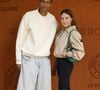 tout aussi détendue auprès de son mari, avec un legging noir et des sandales assorties, le tout complété par une somptueuse veste Lacoste beige et un joli sac vert.

Stromae et sa femme Coralie Barbier lors des Internationaux de France de Tennis de Roland Garros 2026, à Paris, France, le 7 juin 2026. © Jacovides-Moreau/Bestimage