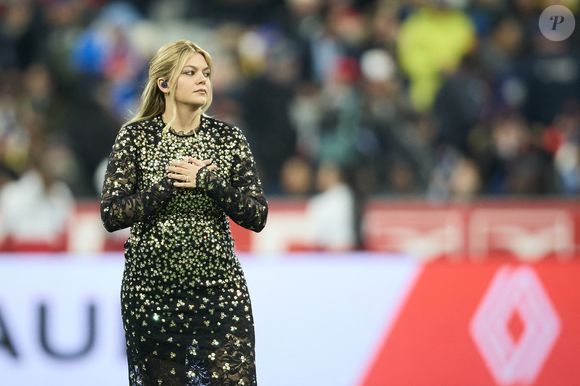 La chanteuse Louane (Louane Emera), représentante de la France au concours de l'Eurovision, interpréte pour la première fois son titre Maman, en hommage à sa mère décédée lorsqu'elle avait 17 ans, devant les 80 000 spectateurs, suspendue sur une plateforme, plusieurs mètres au-dessus de la pelouse et des musiciens, du Stade de France à la mi-temps du match du Tournoi des Six Nations opposant la France à l'Écosse, à Saint-Denis, Seine Saint-Denis, France, le 15 mars 2025. © Cyril Moreau/Bestimage